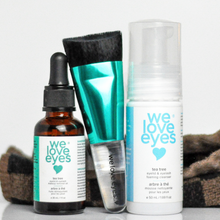 Load image into Gallery viewer, A set of eye makeup removal products including a cleansing brush, a bottle of oil, and a tube of cream from We Love Eyes brand, displayed alongside a free cosmetic bag.
