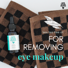 Load image into Gallery viewer, Bottle of 'we love eyes' tea tree oil with checkered towels on a white background