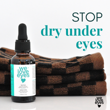 Load image into Gallery viewer, Bottle of 'we love eyes' eye serum with text 'Stop dry under eyes' and folded brown towel on a white background.