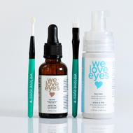 Set of 'we love eyes' skincare products including a dropper bottle, serum, and applicator on a white background.