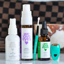 Load image into Gallery viewer, Set of 'we love eyes' eye care products on a reflective surface with a checkered towel in the background.
